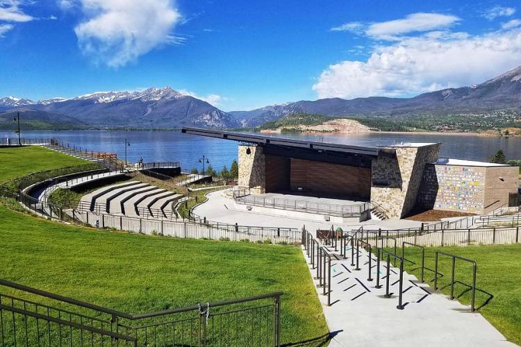 Ampitheatre with seating and lake and mountain views behind it. 