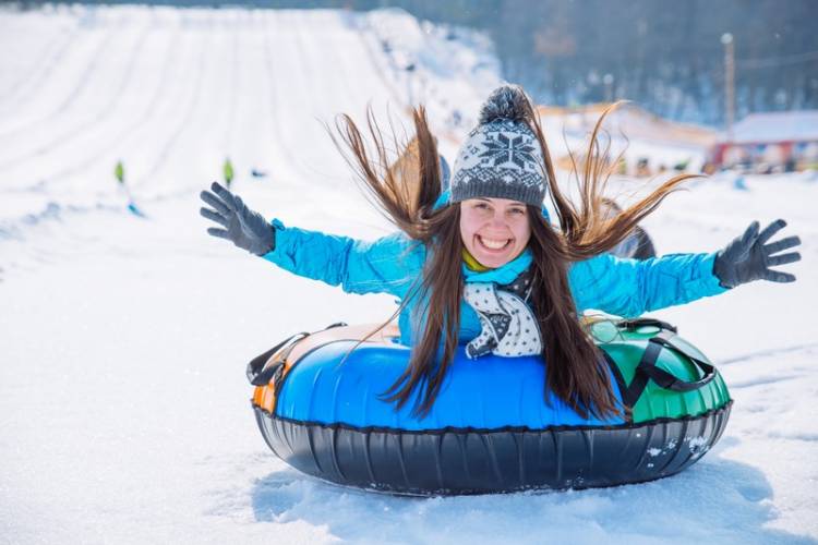 girl on a snow tube sliding down the snow. 