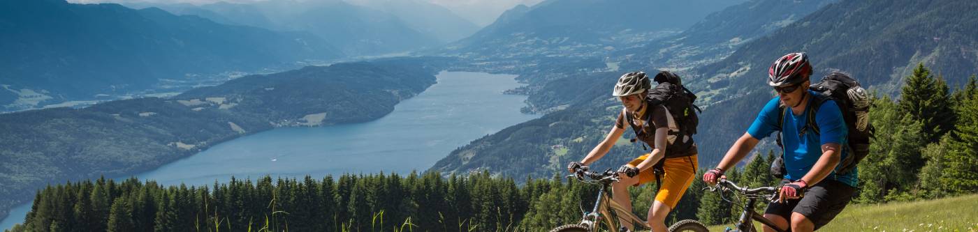 two people biking along a mountain trail